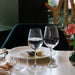 Three wine glasses with water on a table with a blurred background