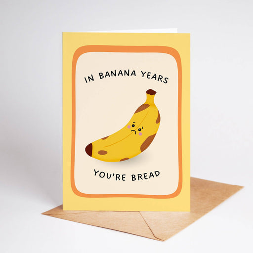 Greeting card with a banana illustration and text 'In banana years you're bread' on a white background.