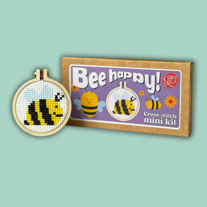 Cross stitch mini kit with bee design and 'Bee happy!' text on a light green background