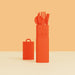 Red utensil holder with cutlery on a peach background