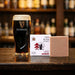 Guinness glass and soap bar on a bar counter with blurred bottles in the background