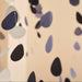 Teardrop-shaped paper garland in black, dark navy, and muted lavender hanging against a warm beige background.