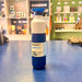 Blue and white Dopper water bottle on a blue table with shelves in the background