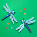 Colorful dragonfly-shaped objects on a green background