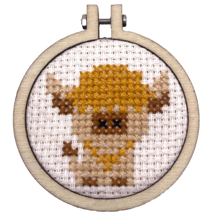 cross stitch embroidery hoop featuring cow design