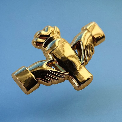 A shiny gold metallic pin shaped like two clasped hands around a pint glass, photographed against a smooth light blue background.