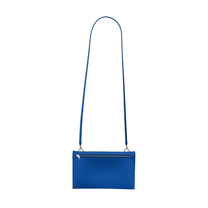 A vibrant blue leather crossbody clutch bag with a long, slender strap and a silver zipper closure, shown against a plain white background.
