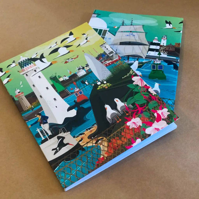 Two colorful notebooks with illustrated covers on a brown surface