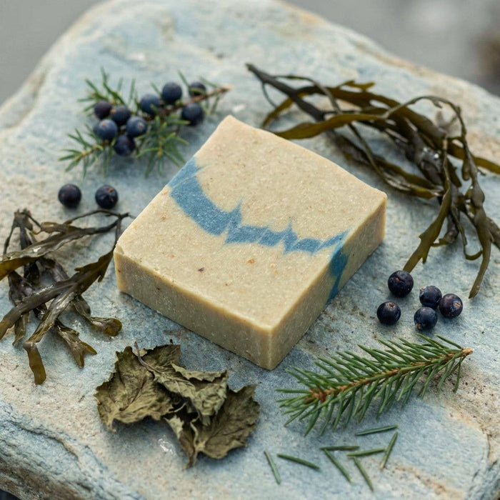 Bar of soap with natural elements on a stone surface