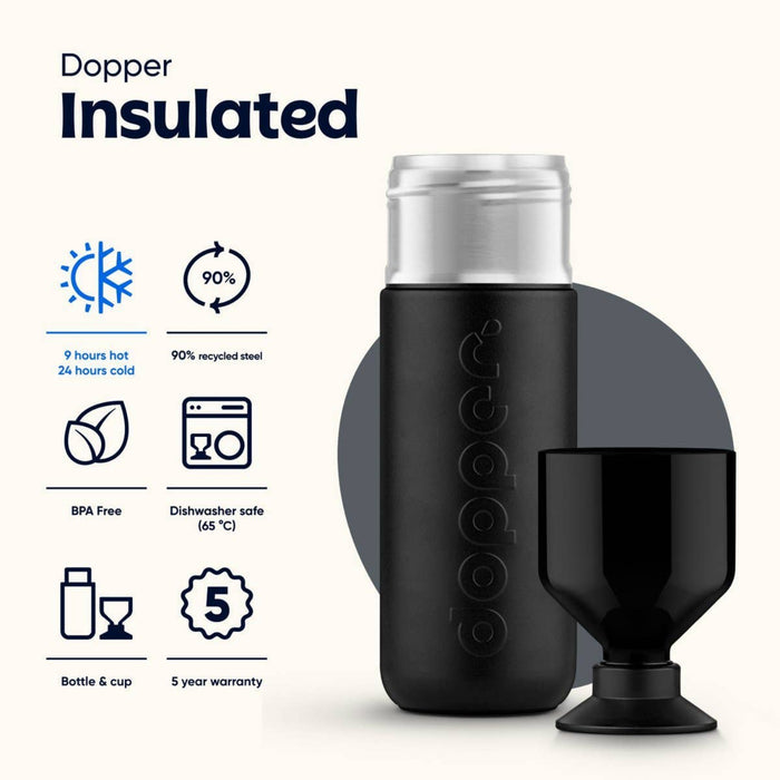 Dopper insulated bottle and cup set on a light cream background with feature icons and text. The bottle is matte black with a silver cap and embossed Dopper branding, and the black cup sits beside it.