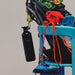 A black insulated water bottle with a carabiner clip hangs from a bright blue chair next to a pile of colorful rolled climbing or outdoor gear, including green, red, and blue fabric.
