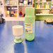 Mint green refillable water bottle and cup on a blue surface with a store shelf in the background.
