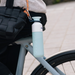 Light blue water bottle attached to a bicycle with a blurred background