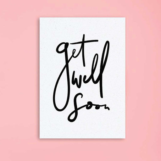 white textured card with Get Well Soon in black cursive text on front  against pink backdrop