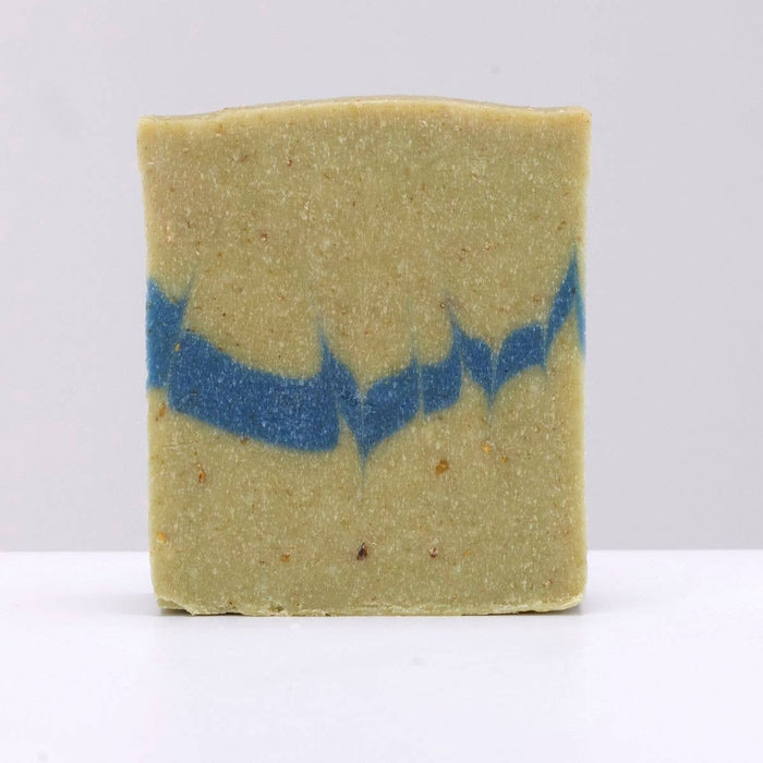 Bar of soap with blue and green coloration on a white background
