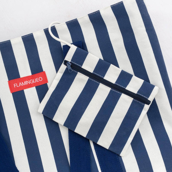 Navy and white striped bag with a pouch on a matching background, featuring the brand 'FLAMINGUO'.