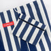 Navy and white striped bag with a pouch on a matching background, featuring the brand 'FLAMINGUO'.