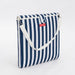 Navy and white striped bag with a red label on a light gray background