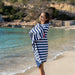 Woman wrapped in a blue and white striped towel on a beach
