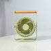 Green portable fan on a white surface with a blurred background