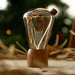 Decorative light bulb with wooden base on a table with blurred Christmas tree in the background