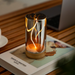 Glass lamp with flame design on a wooden surface
