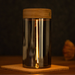 Glass lamp with wooden lid on a dark background.