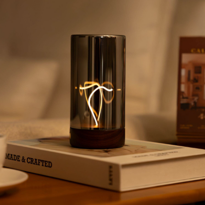 Glass lamp with decorative design on a book titled 'MADE & CRAFTED'.
