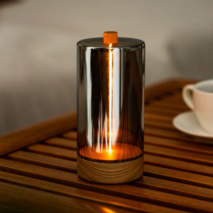 Glass light with wooden base on a wooden surface