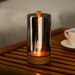 Glass light with wooden base on a wooden surface