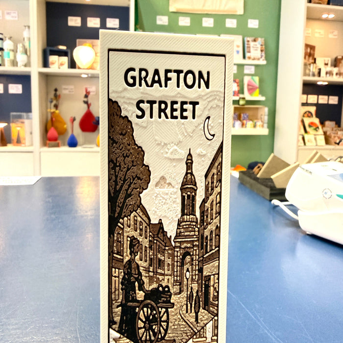 Decorative bookmark with 'Grafton Street' design on a table in a store setting.