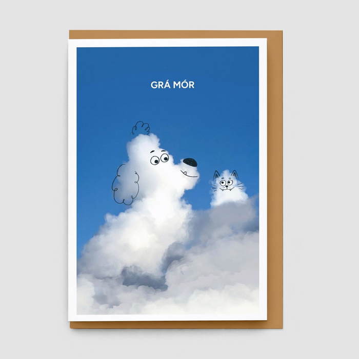 A greeting card with a brown envelope, featuring a blue sky illustration with the text 'GRÁ MÓR' above a fluffy white dog and a small gray cat peeking out from clouds.