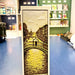 Bridge and cityscape design on a bookmark with blue surface in background.