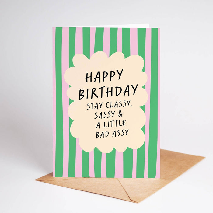 Birthday card with green and pink striped design and humorous text on a white background