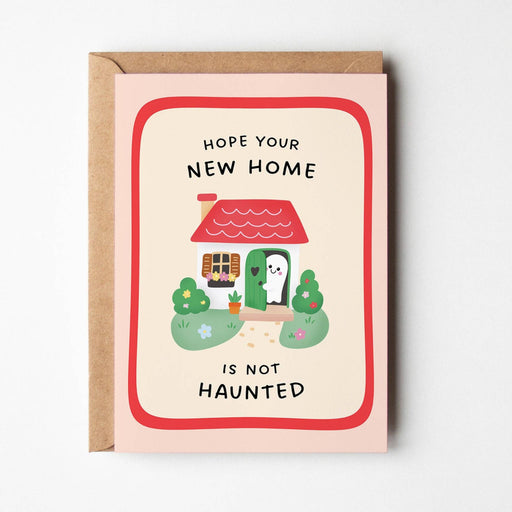 Greeting card with cartoon cat, house, and text 'Hope your new home is not haunted' on a white background