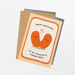 A birthday greeting card with a kraft envelope, featuring a cartoon illustration of two smiling orange human beans with small pink hearts, and the text 'HAPPY BIRTHDAY TO MY FAVOURITE HUMAN BEAN'.