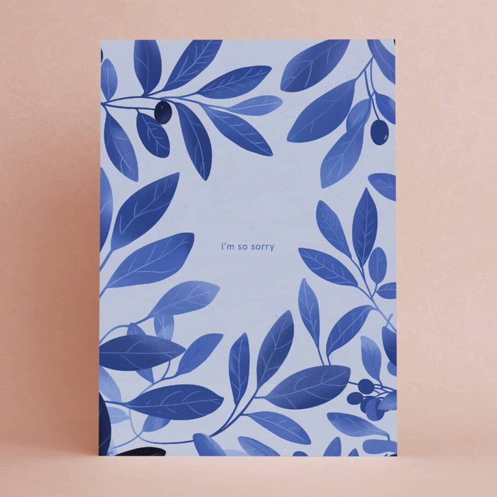 Notebook with blue leaf pattern and 'i'm so sorry' text on a beige background