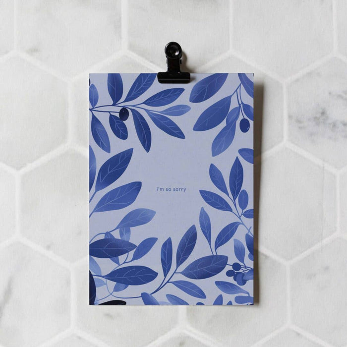 Card with blue leaf pattern and 'I'm so sorry' text on a white marble background