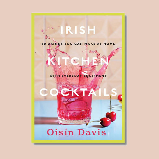 Irish kitchen cocktails book, with yellow boarder and image of a glass on book cover with pink liquid splashing from glass and two cherries on counter top to the right of the glass