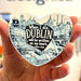 Heart-shaped magnet with Dublin quote held by a hand in front of a white background.