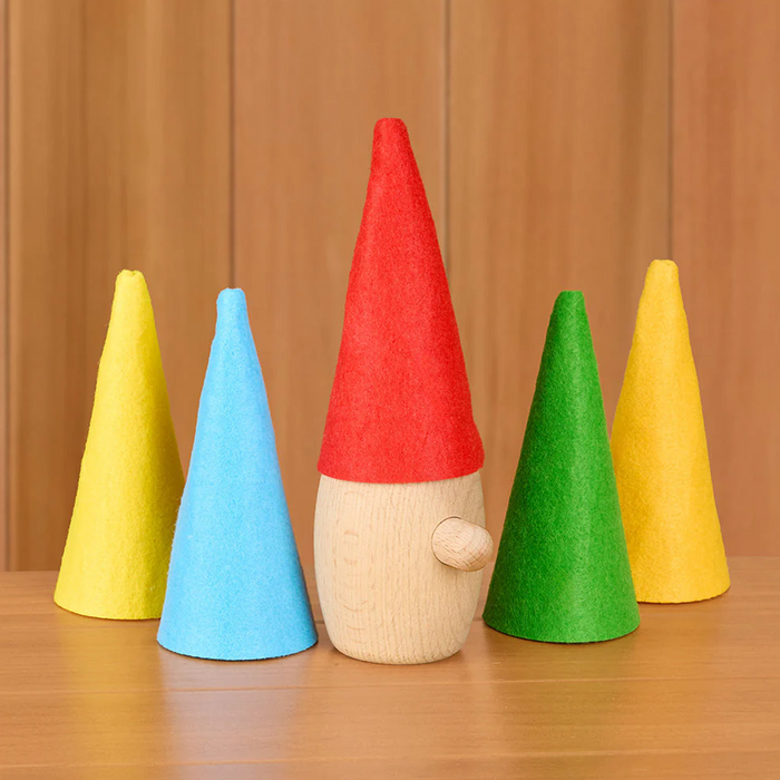 Wooden gnome with colorful hats on a wooden surface