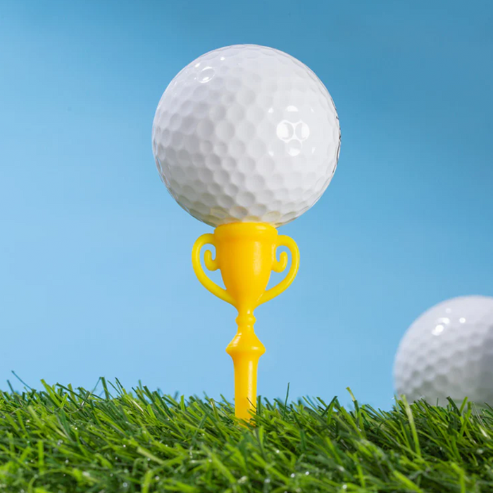 Golf ball on a yellow trophy-shaped tee with a clear blue sky background