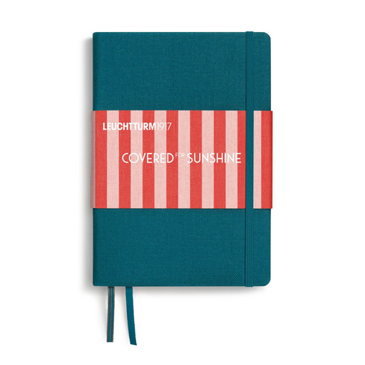 A hardcover notebook with a teal blue cover, a red and white striped paper band across the middle, and white text reading 'LEUCHTTURM1917' and 'COVERED IN SUNSHINE'. A matching teal ribbon bookmark hangs from the bottom on a white background.