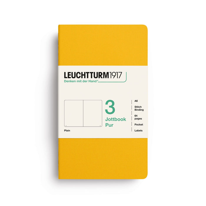 A Leuchtturm1917 notebook in a solid mustard yellow cover with a white paper band label, shown on a clean white background.