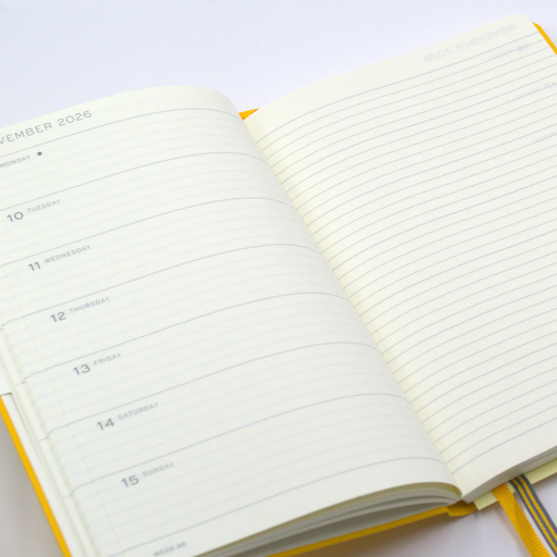 An open lined planner showing the date November 15, 2026, with cream pages and a yellow cover edge, photographed on a clean white background.