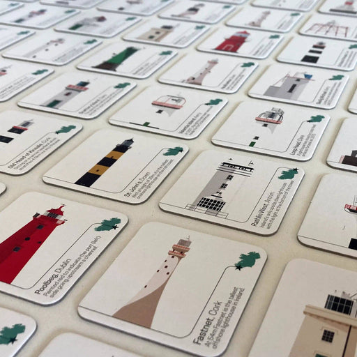 Collection of cards with illustrations of lighthouses and text on a beige surface