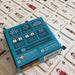 Rear of card game packaging on top of game cards featuring illustrations of lighthouses on a light surface.