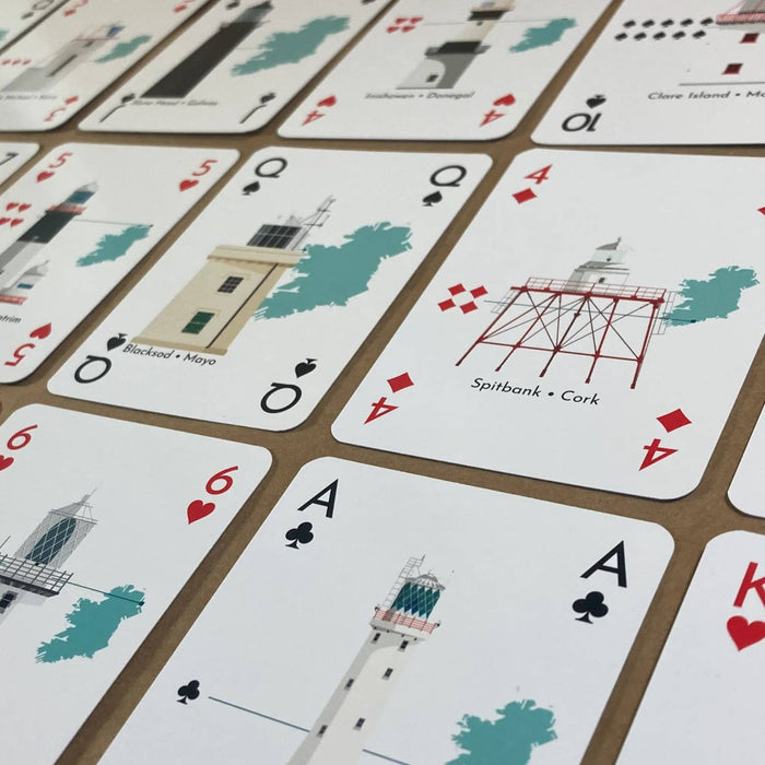 Playing cards with lighthouse illustrations on a brown background