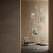 Wall with framed pictures and a chair in a room with a neutral color scheme
