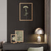 Modern interior with a dark wall, framed artwork, and a chair.